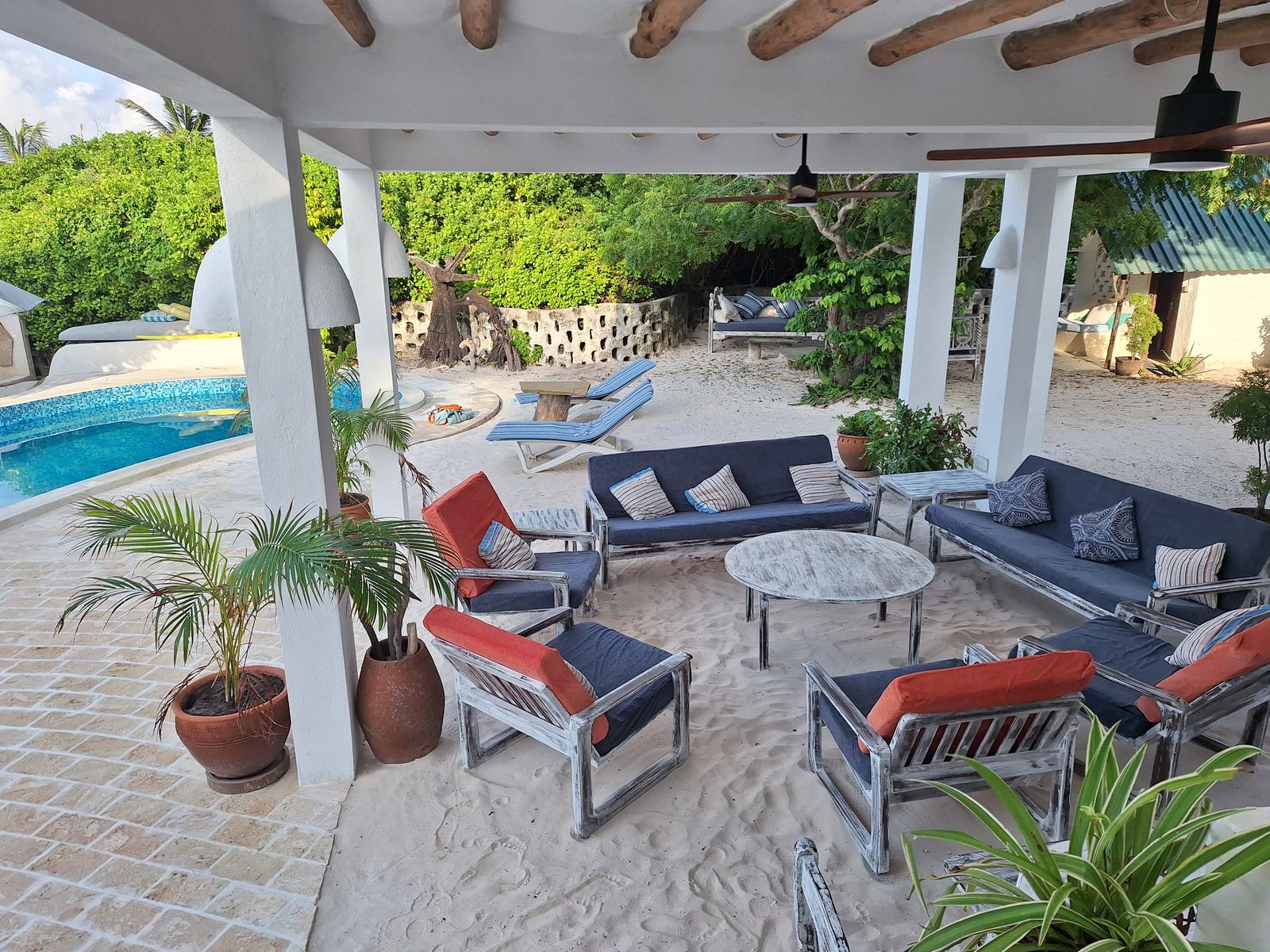 Shaded lounge under the house with sofas beside the pool